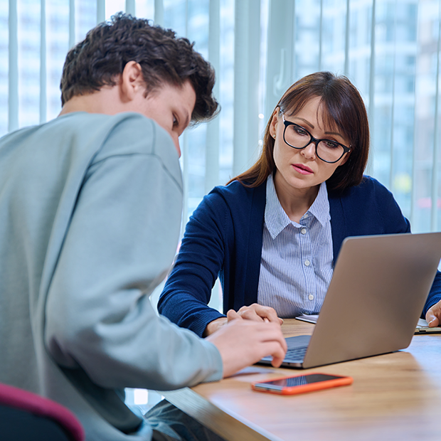 A man and a woman looking at a laptop